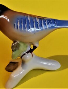 Porzellan-Vogelfigur sitzend auf einen Ast. - Aachen