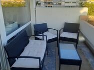 Dunkelgraue Gartenmöbel mit Couchtisch und cremefarbenen Kissen - München