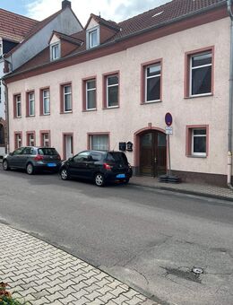 Das Grundstück ist mit einem Mehrfamilienhaus inklusive einer Ladenfläche sowie mit drei Garagen bebaut. - Rötha