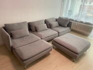 Graues Sofa mit Kissen und Hocker - Gengenbach